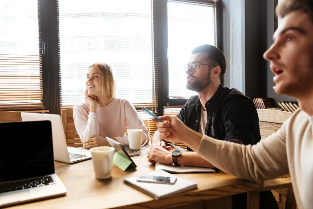 Cheerful young colleagues sitting in office - Freepik
